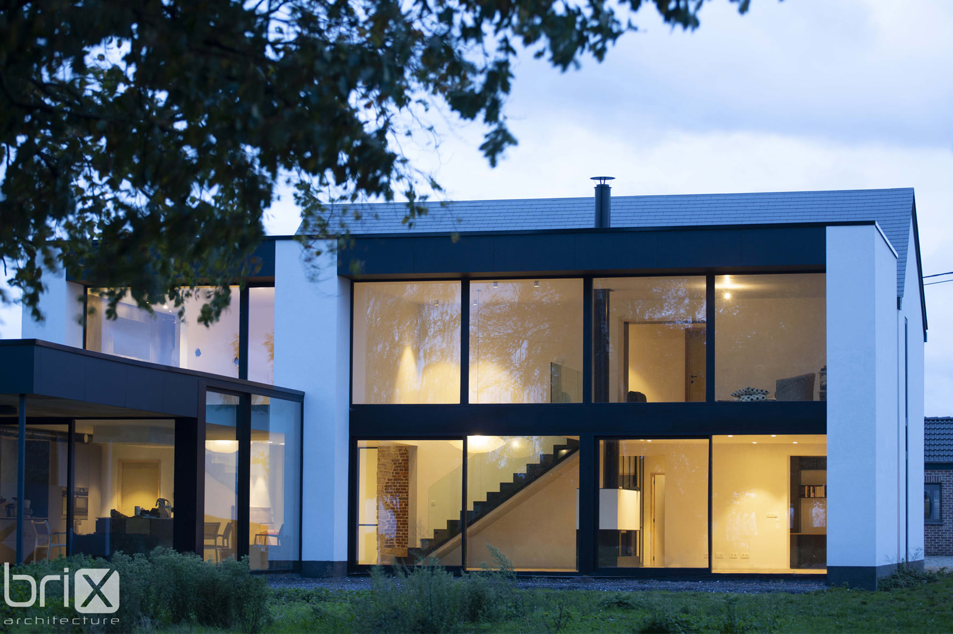 maison vue du jardin, la façade est entièrement vitrée donnant à l'ensemble un style très contemporain