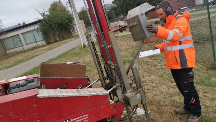 Regis, un ouvrier de BNS test une carroteuse rouge devant une route