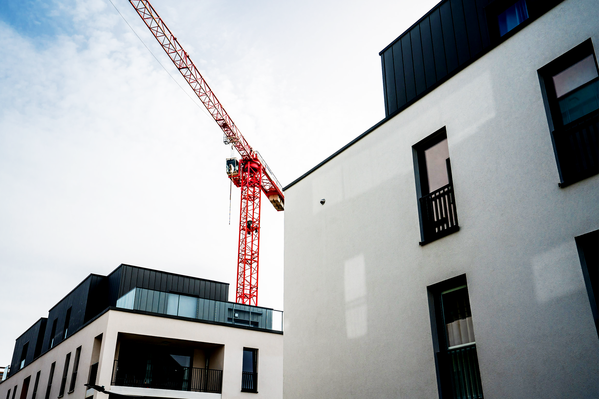 Une grue rouge entre 2 immeubles neufs